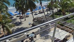 A beach view with palm trees, umbrellas, and lounge chairs. - Yaque Beach Hotel (Díaz)
