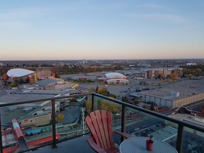 A high-rise building with a view of a cityscape, including a stadium and industrial buildings. - Monki-Di Executive Suites - Alura (Calgary)