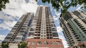 A high-rise building with multiple floors, large windows, and balconies. - Monki-Di Executive Suites - Alura (Calgary)