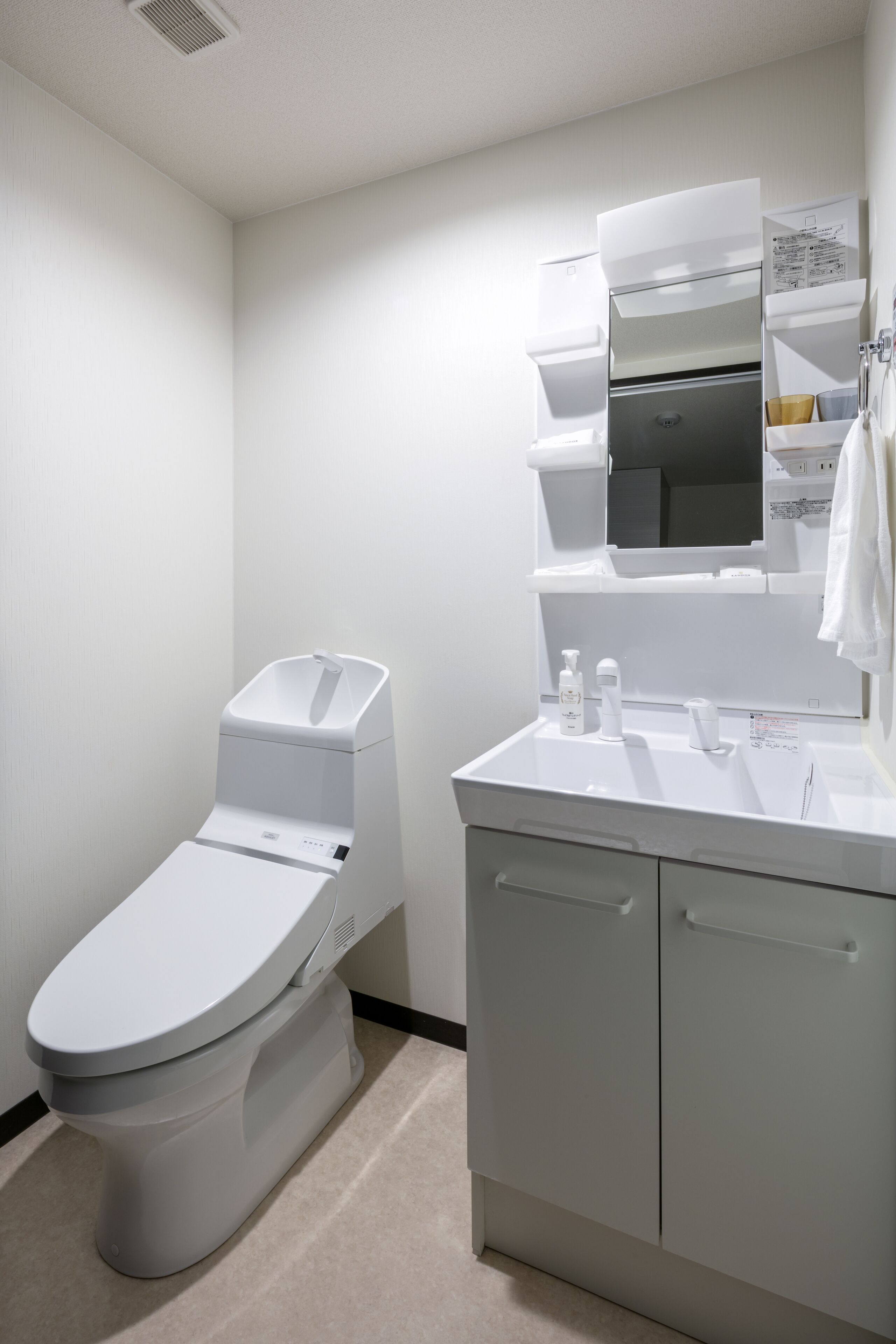 A modern bathroom with a toilet, sink, and cabinet.