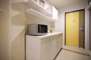Quarto luxo | Espaço de cozinha compartilhada | Geladeira, micro-ondas em uma área comum, chaleira elétrica