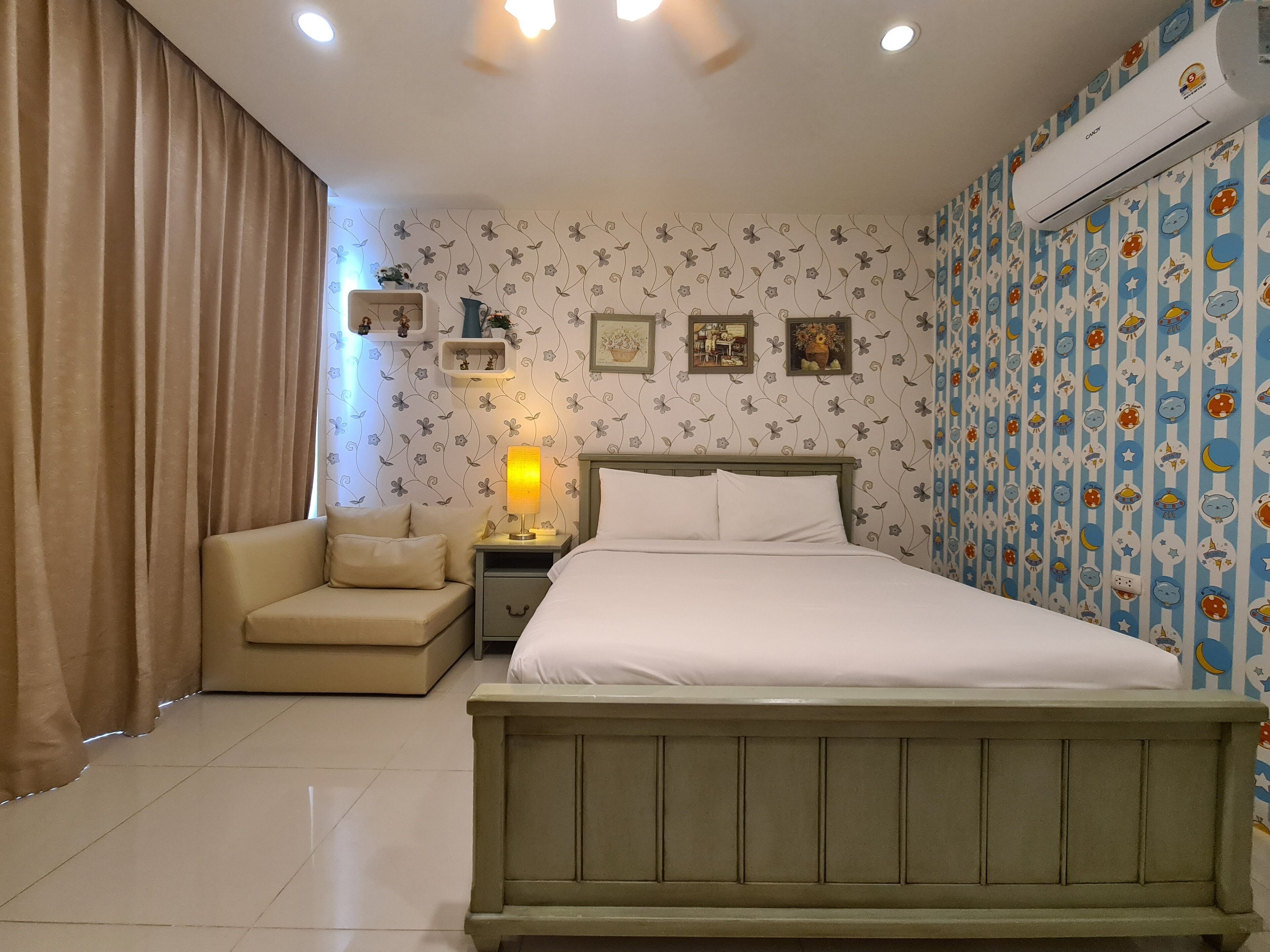 A bedroom with a bed, a nightstand, a lamp, a chair, and a wardrobe.