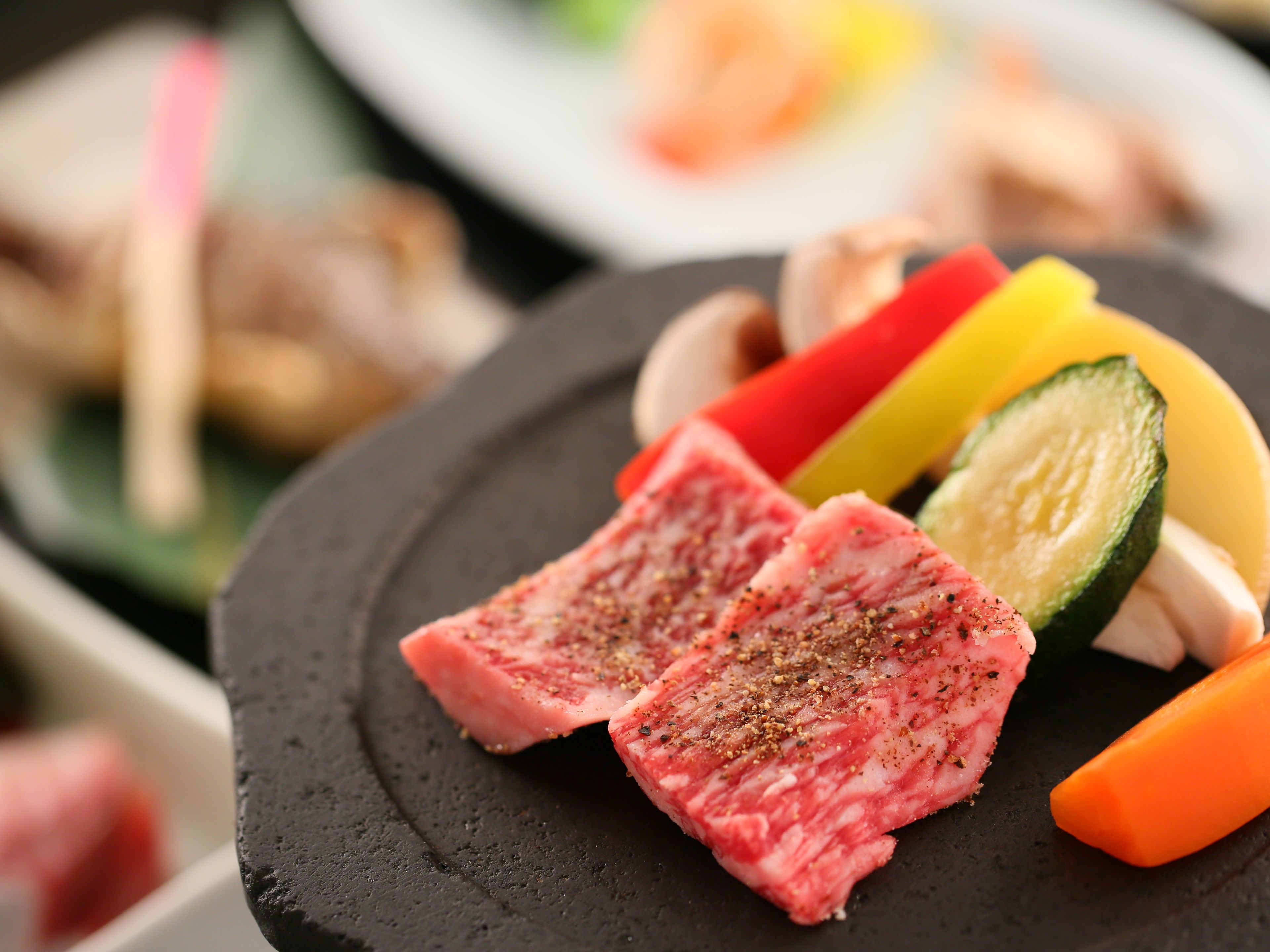 Une vue rapprochée d’une assiette contenant des tranches de viande, des légumes et des champignons.