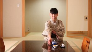 A traditional Japanese room with tatami flooring, a low table, and a person in a kimono. - Awanoyu (Matsumoto)