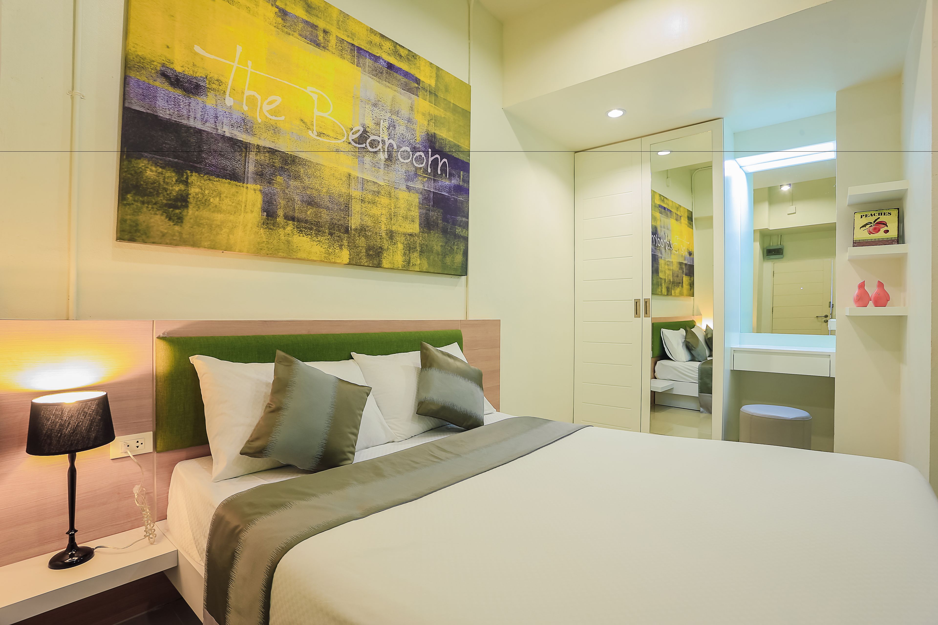 Un dormitorio moderno con cama, mesita de noche y un cuadro abstracto grande en la pared.