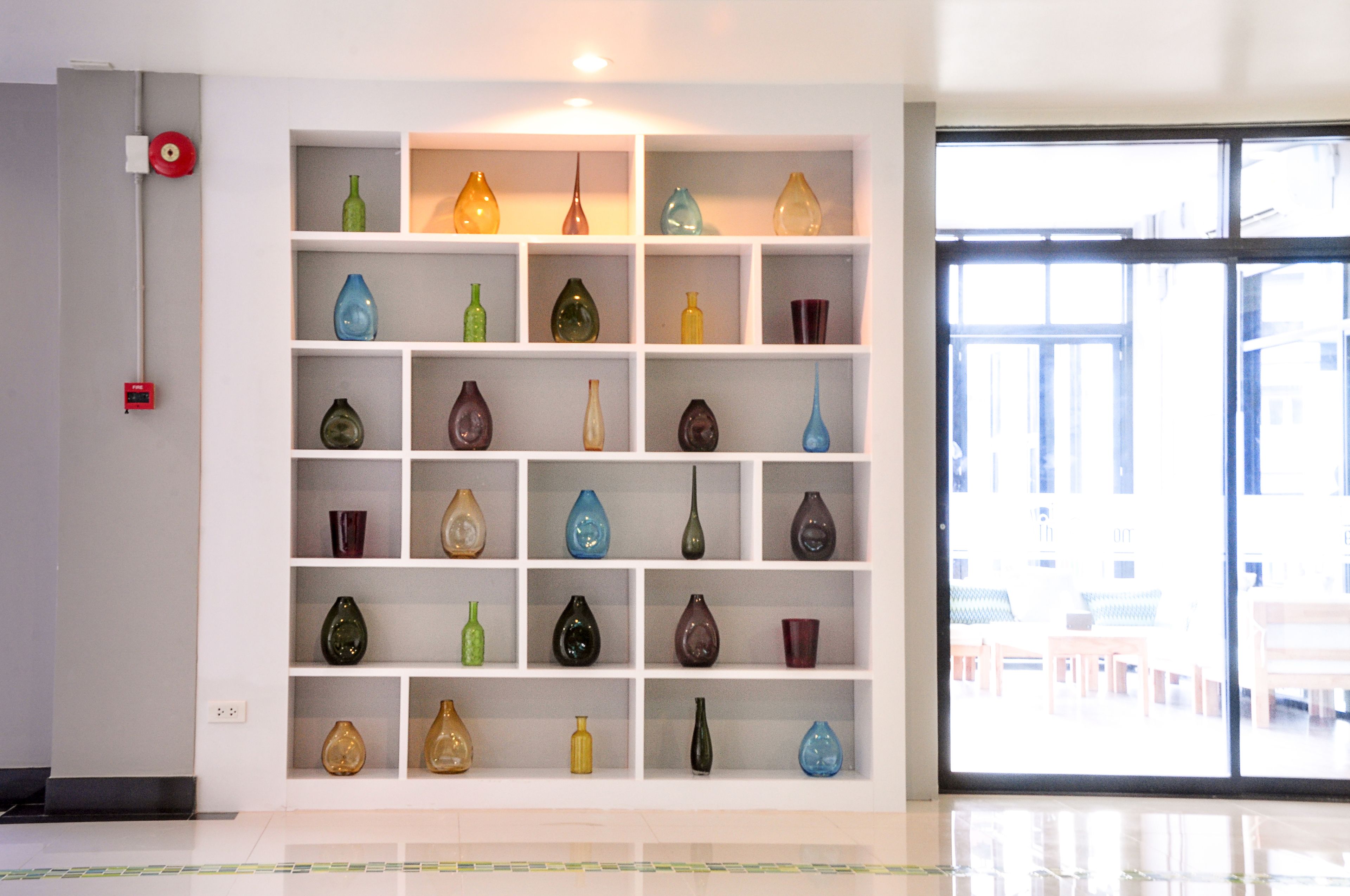 Una parete decorata con composizioni di vasi colorati in un ambiente moderno.