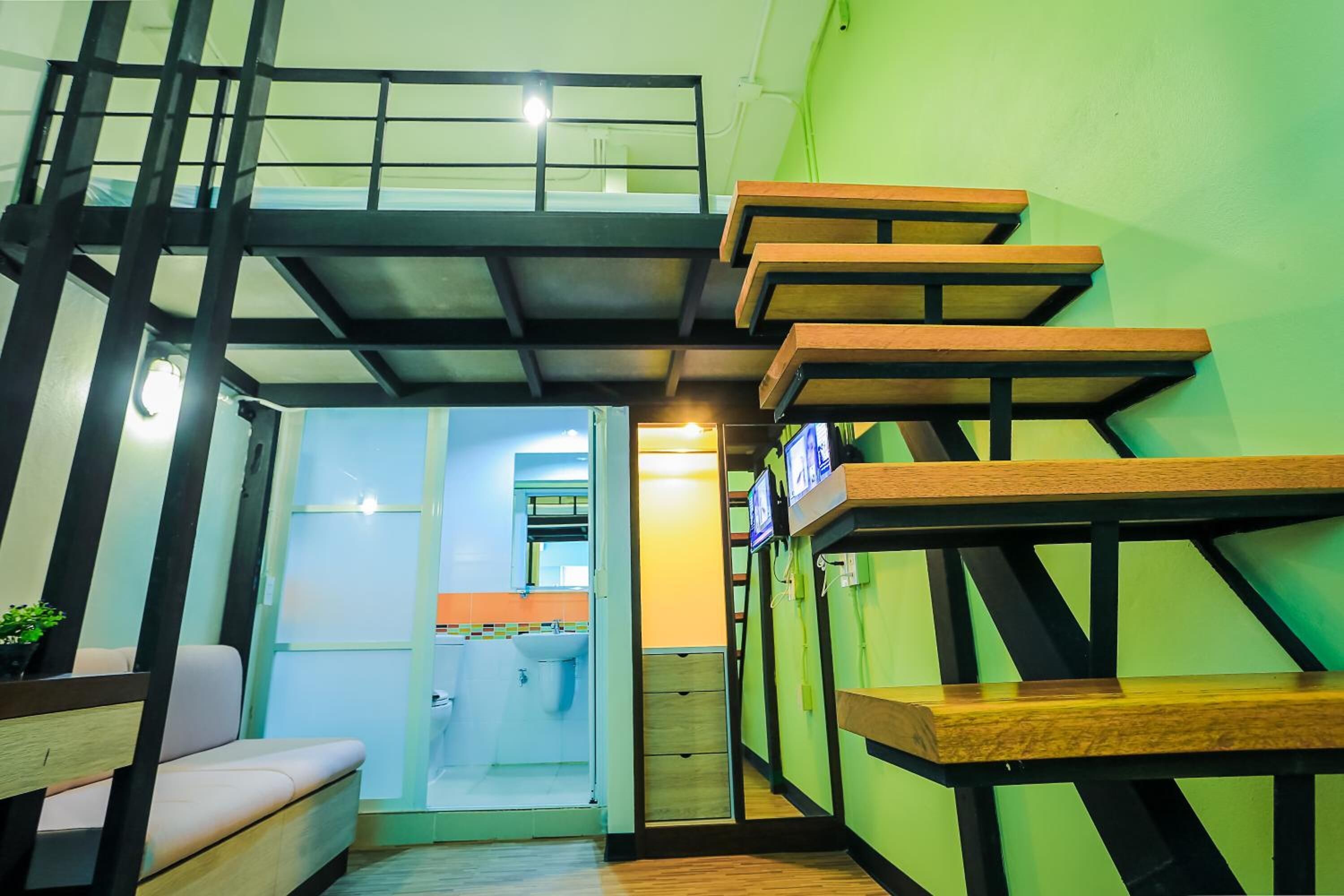 A staircase with wooden steps and metal railings, leading to a second-floor balcony.