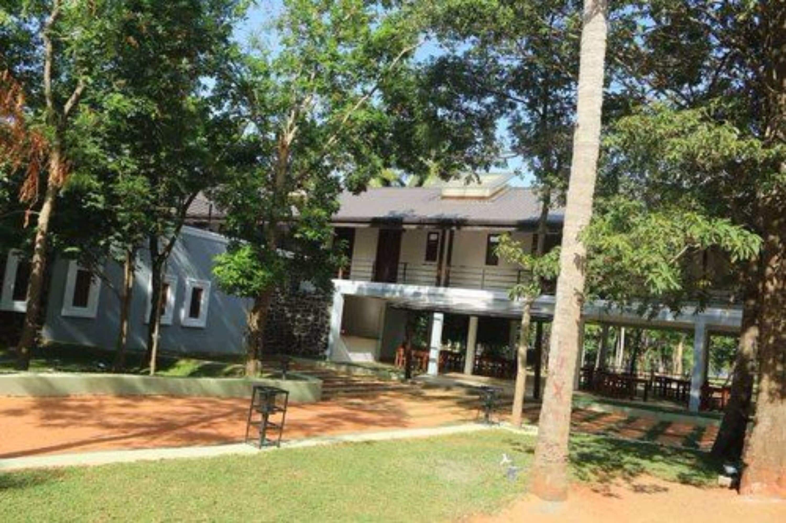 A building with a covered outdoor area, surrounded by trees.
