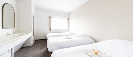 A hotel room with a white bathroom, two beds, a large mirror, and a window with curtains.