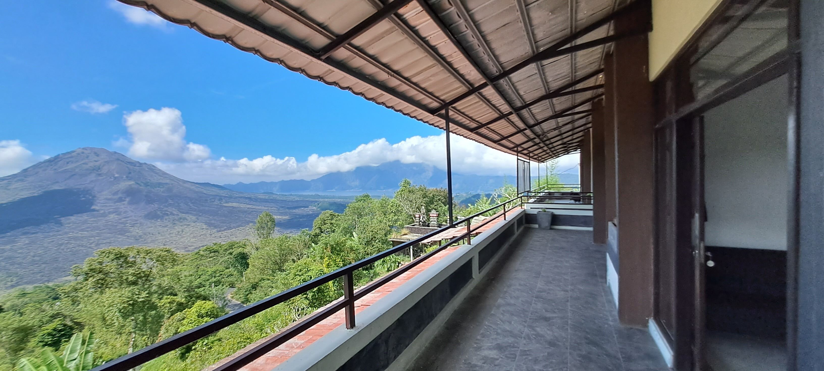 Un balcon offrant une vue sur une montagne et une végétation luxuriante.