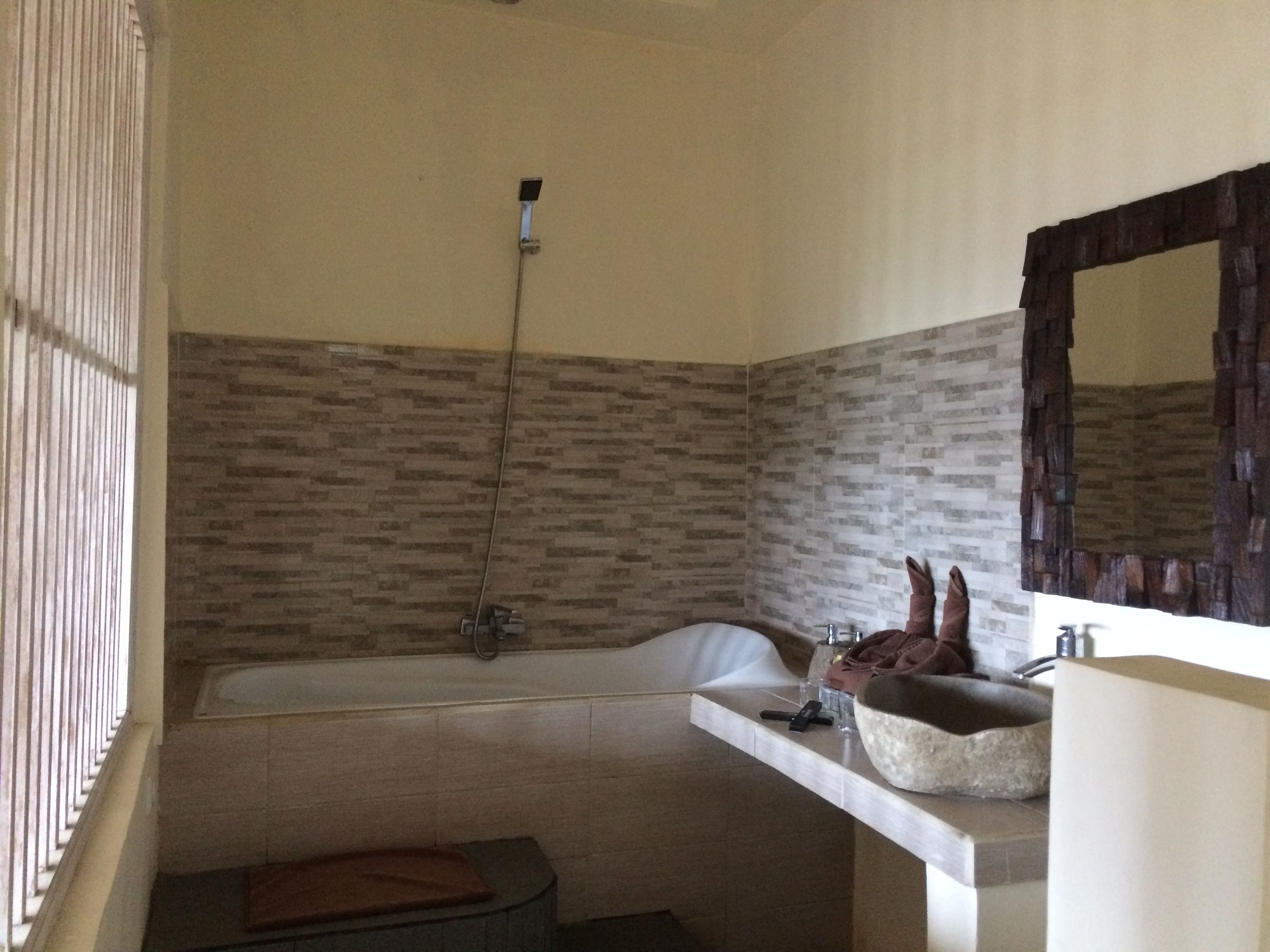A bathroom with a bathtub, a sink, and a mirror.