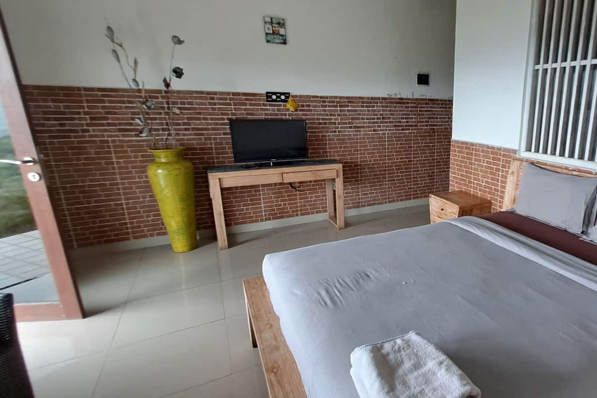 Quarto com cama, televisão, mesinha e janela com grades.