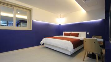 Une chambre à coucher avec un lit, un bureau et une chaise.