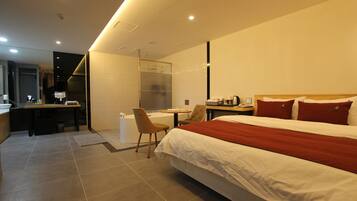 Una habitación de hotel moderna con una cama grande, un escritorio y una silla.