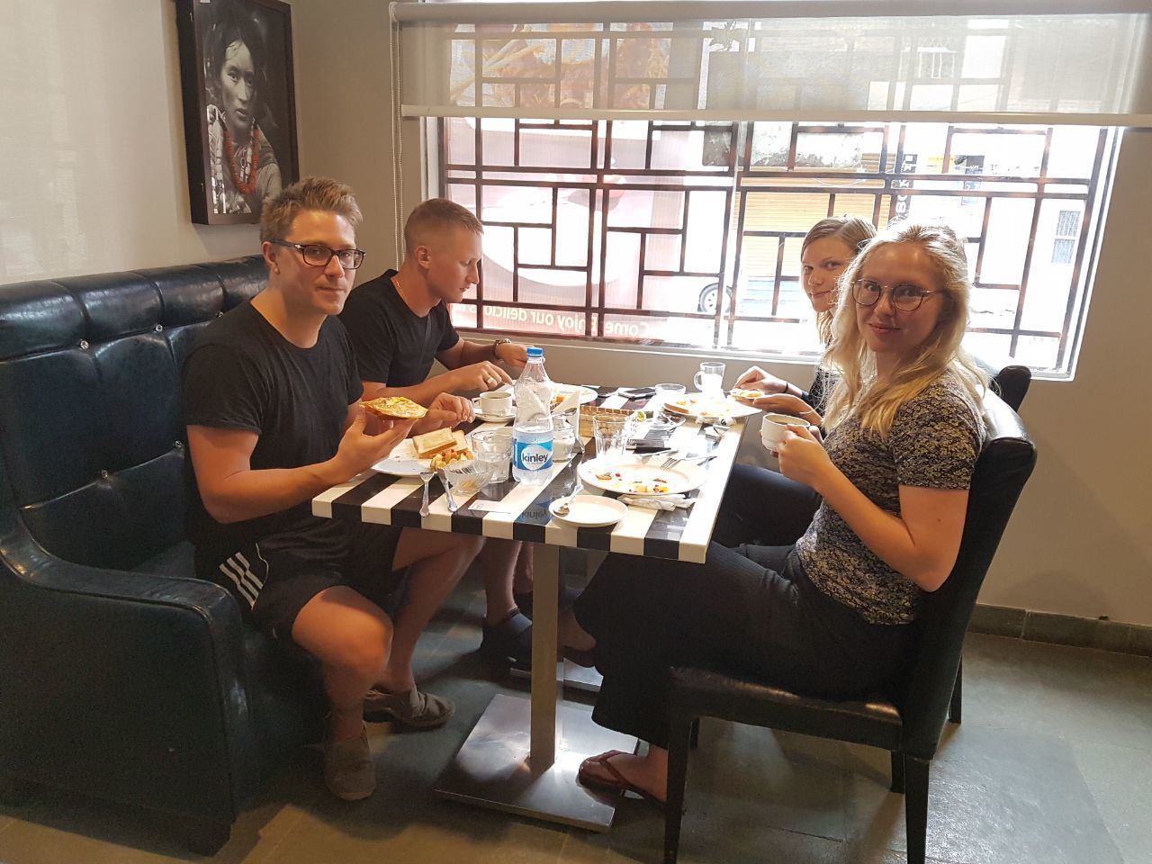 A group of people dining at a table with a window view.