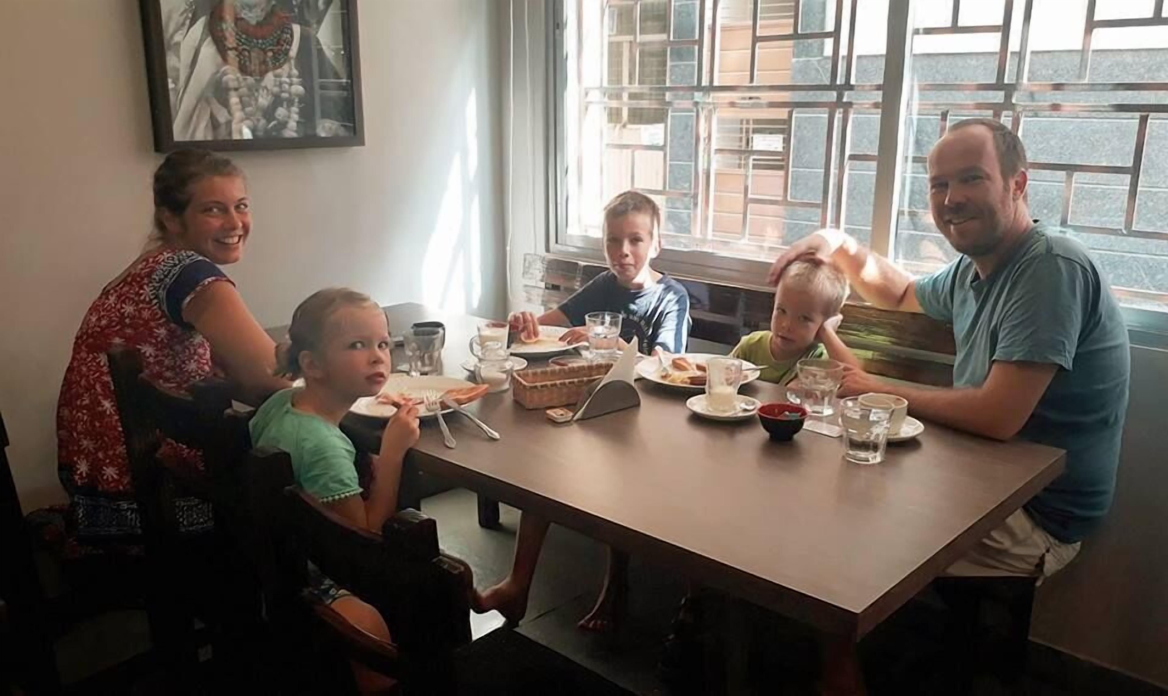A family dining at a table with various dishes and drinks.
