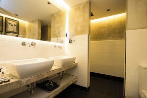A modern bathroom with two sinks, a mirror, and a shower area.