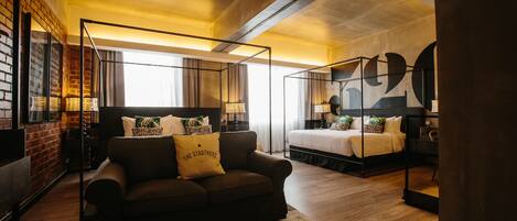 Une chambre d’hôtel moderne avec un canapé, un lit et un grand miroir.