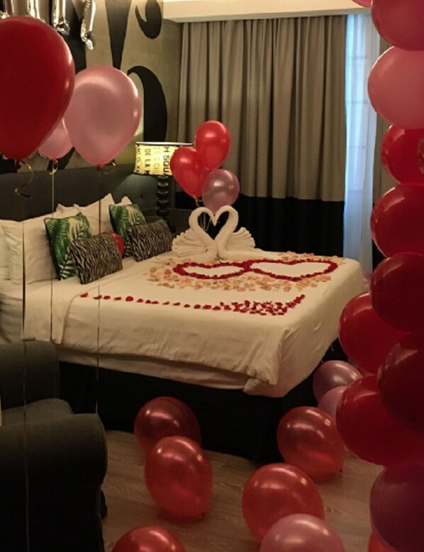 A bed with a heart-shaped decoration, pillows, and balloons. - Rosa Malacca (Malacca City)