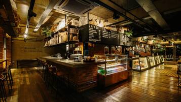 A coffee shop with a counter, seating area, and a display case.