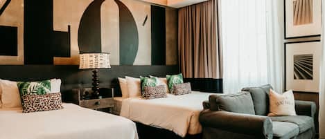 Habitación de hotel con dos camas, un sofá y una gran obra de arte abstracta en la pared.