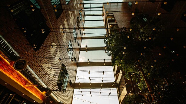 An indoor space with a high ceiling, exposed brick walls, and string lights. - Rosa Malacca (Malacca City)