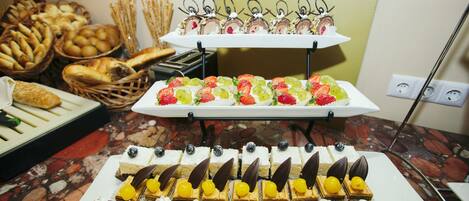 A buffet with various desserts and bread baskets.