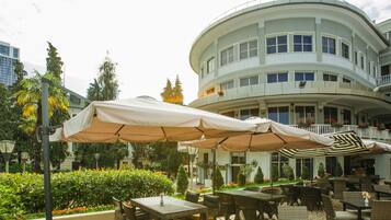 A hotel courtyard with outdoor seating, a curved building, and a sign for the concierge.