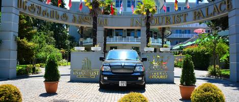 Un edificio con un cartel que dice "INTOURIST PALACE" y un coche estacionado frente a él.