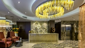 A lobby with a checkered floor, a reception desk, a chandelier, and seating areas. - The Raintree Dhaka (Dhaka)