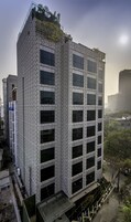 A modern building with a geometric facade and multiple windows.