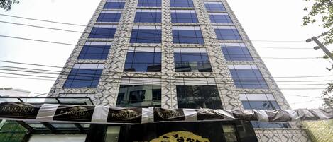 A tall building with a modern facade, featuring a prominent logo at the ground level.