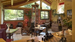 A cozy wooden interior with a dining area, chairs, a table, and a chessboard. - Hôtel Auberge du Morge (Les Echelles)