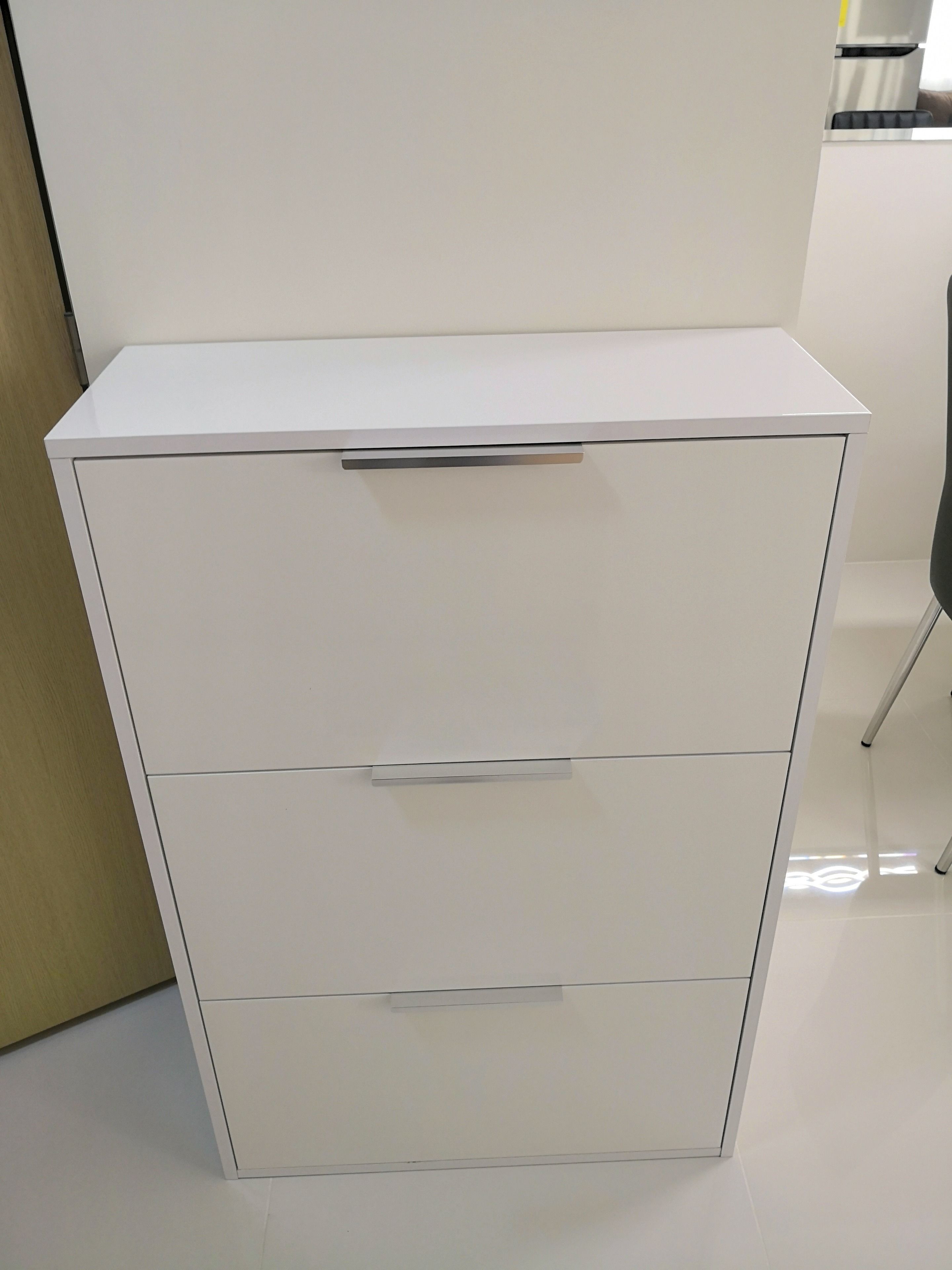 A white filing cabinet with two drawers and a handle on the top.