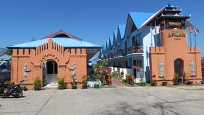 A hotel with a traditional architectural style, featuring a prominent entrance with statues and a blue-roofed building. - Kyauk Phyu Palace Resort Hotel (Kyaukpyu)