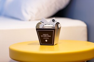 Uma pequena caixa preta com texto branco sobre um banquinho amarelo.