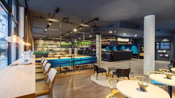 Un restaurante moderno con zona de bar, diferentes distribuciones de mesas y vistas panorámicas del paisaje urbano a través de amplios ventanales.