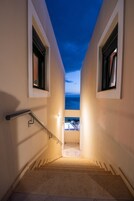 Una escalera conduce a un balcón con vistas al mar.