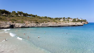 Una spiaggia nelle vicinanze, sabbia bianca, lettini da mare, ombrelloni