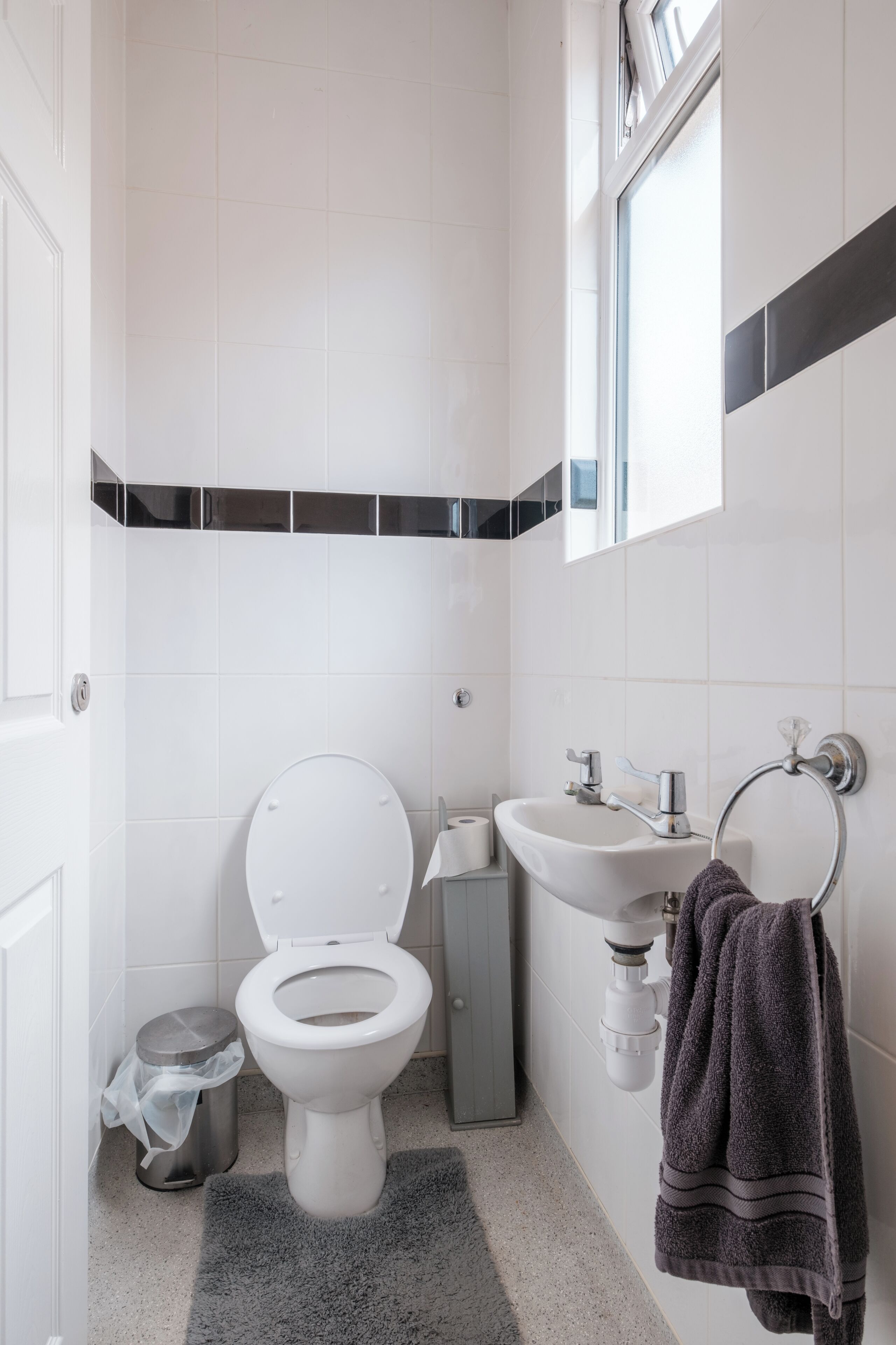 Un bagno moderno con servizi igienici, lavandino e porta asciugamani.