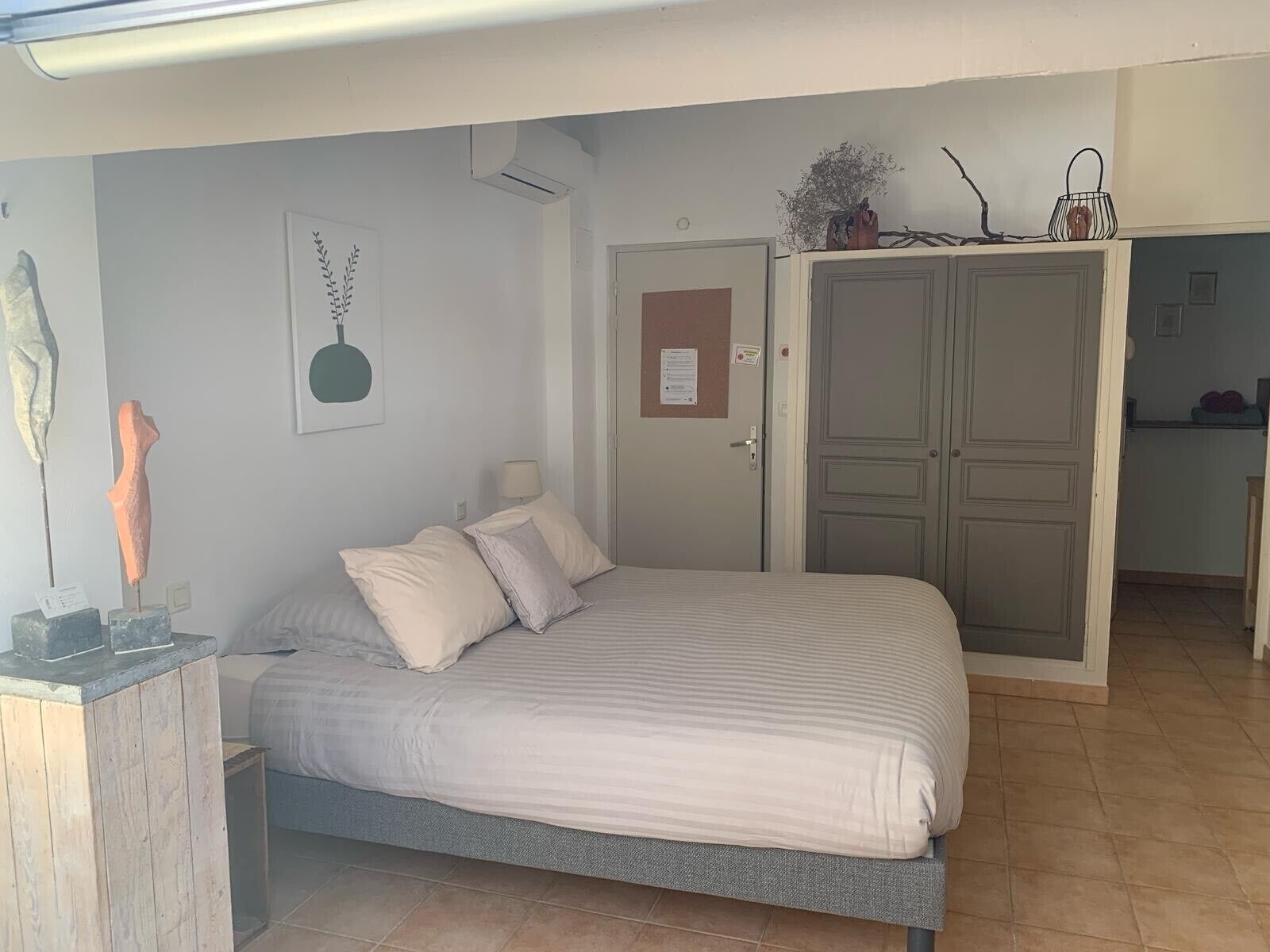 Ein Schlafzimmer mit einem Bett, einem Kleiderschrank und einem kleinen Schreibtisch mit Lampe.