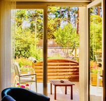 Habitación con vista a un jardín a través de un ventanal.