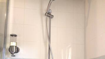 Une douche équipée d’un pommeau de douche à main et d’un robinet fixé au mur.