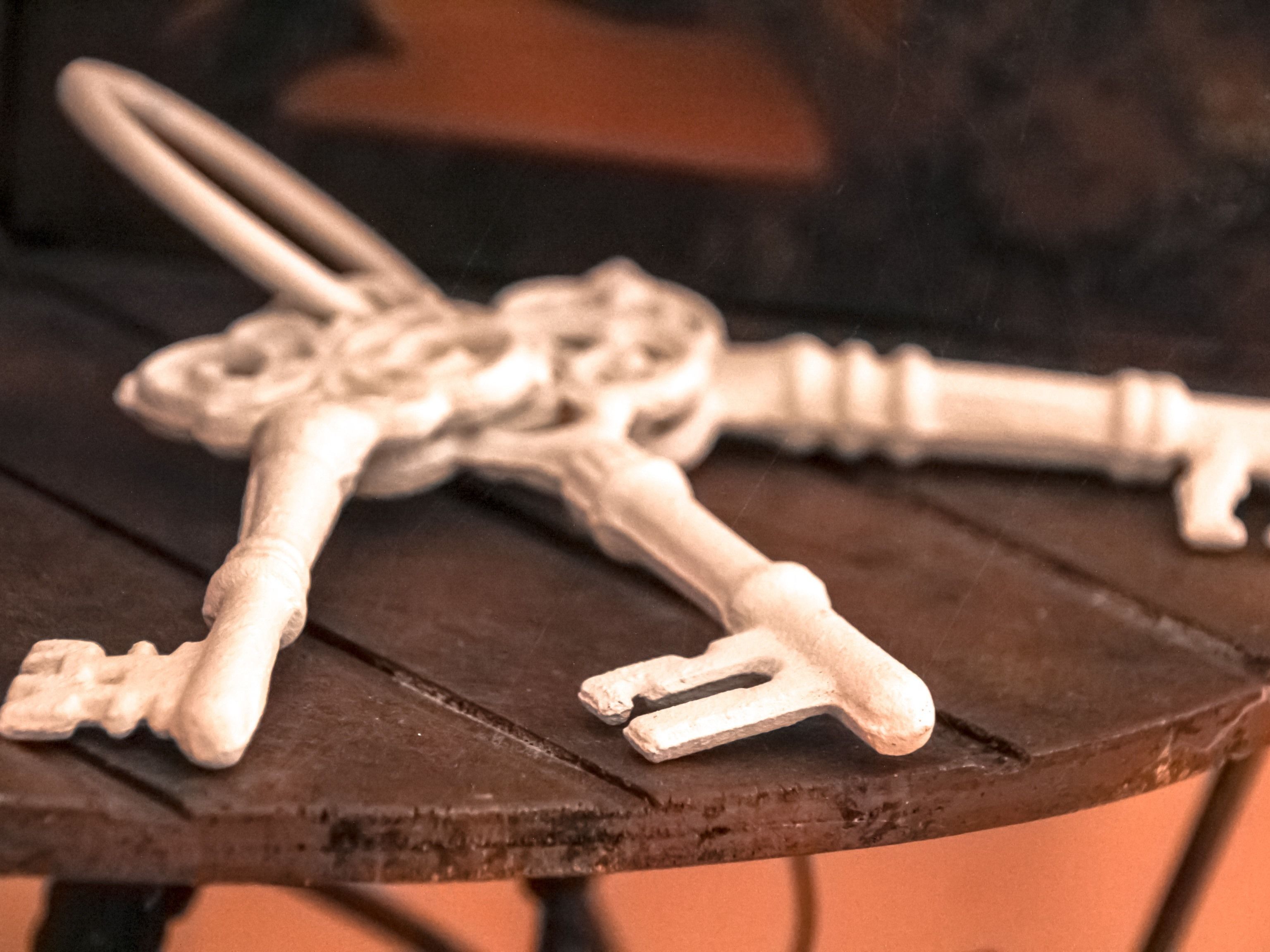 A close-up of three antique keys on a wooden surface.