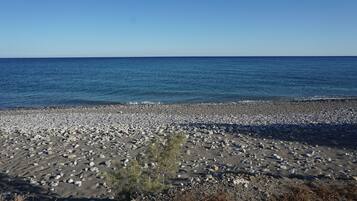 En la playa, sillas reclinables de playa, sombrillas