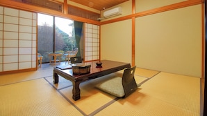 A traditional Japanese room with tatami flooring, a low wooden table, and sliding doors. - Hotel Kinu (Nikko)