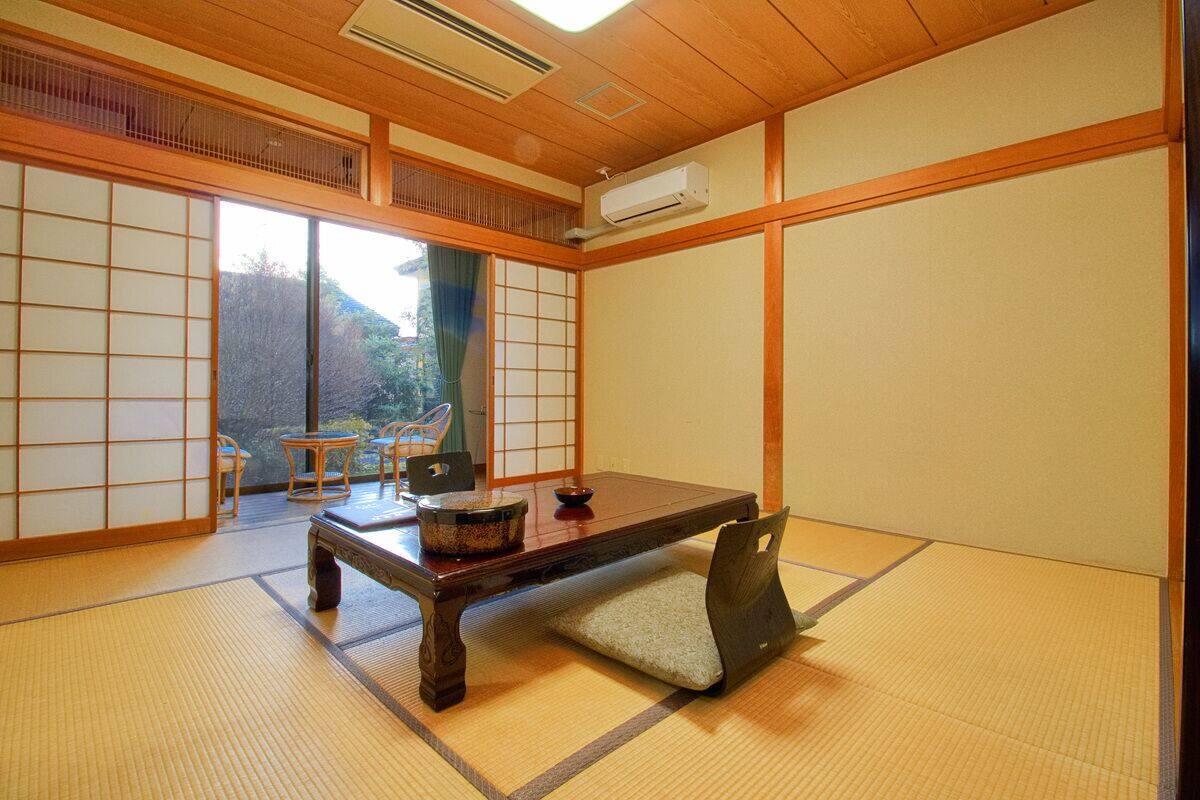 Ein traditioneller japanischer Raum mit Tatami-Böden, einem niedrigen Tisch und Schiebetüren.