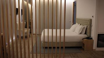 Een slaapkamer met een bed, nachtkastje en stoel.