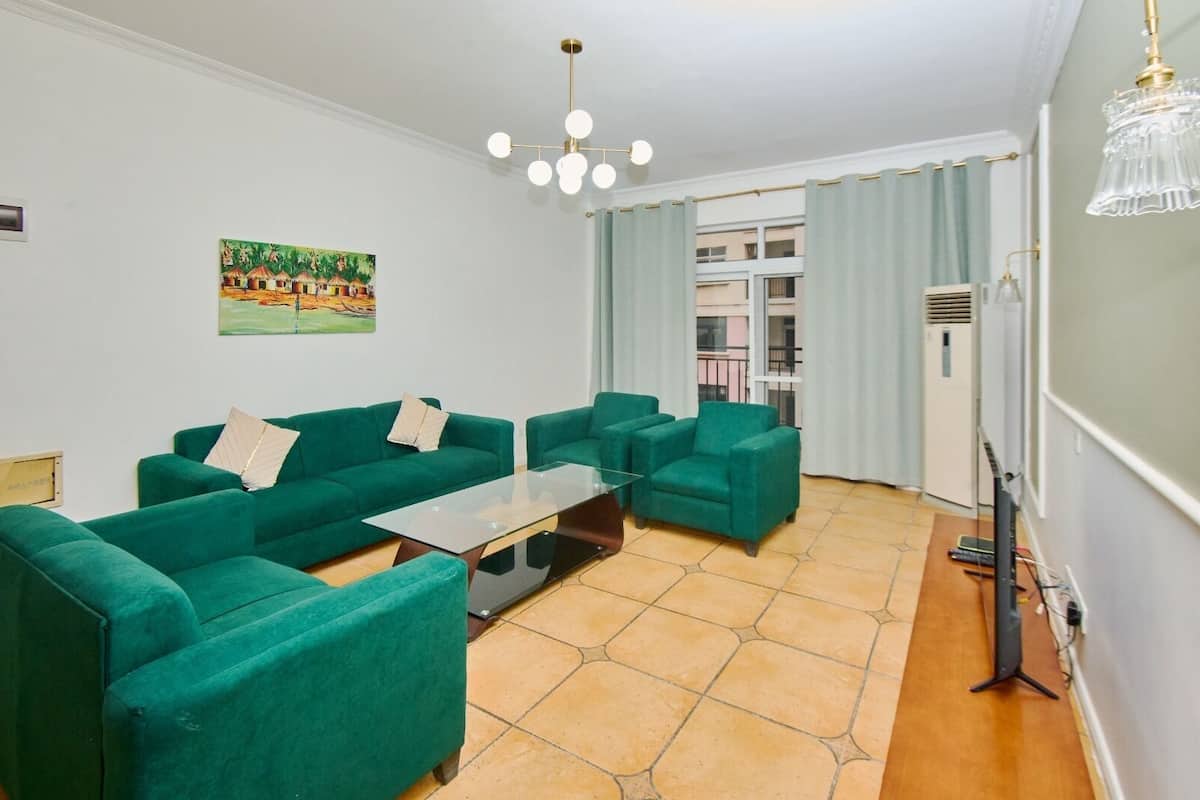 Un salon comprenant un canapé, une table basse en verre et un tableau accroché au mur.