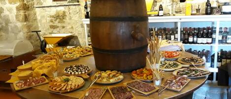 A food display with various dishes and a wine rack in the background.